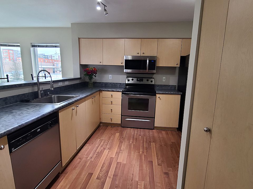From the hallway looking into the kitchen. Stainless steel stove, refrigerator, microwave and dishwasher.
