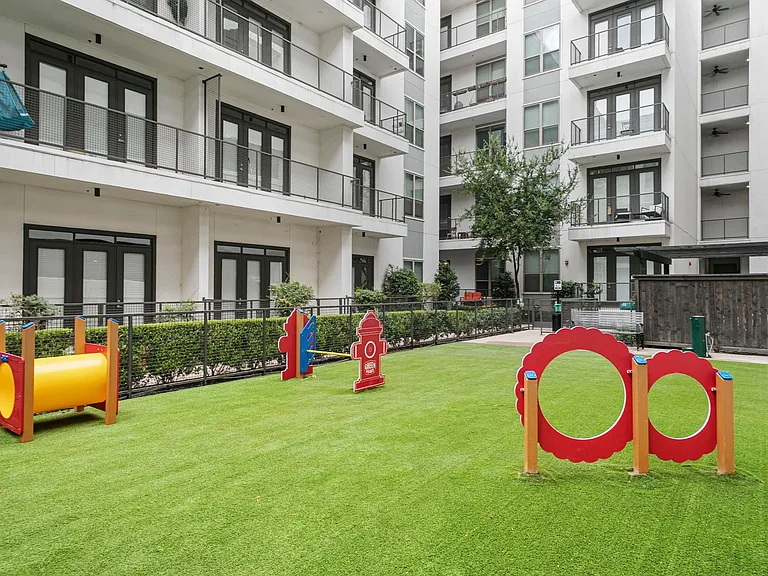 Leash-free dog park with agility games, benches, and lots of grassy area.