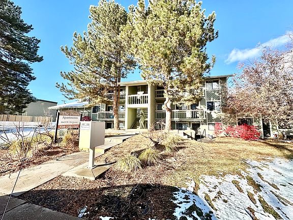 Charming exterior of The Pines Apartments with lush greenery and modern architecture.