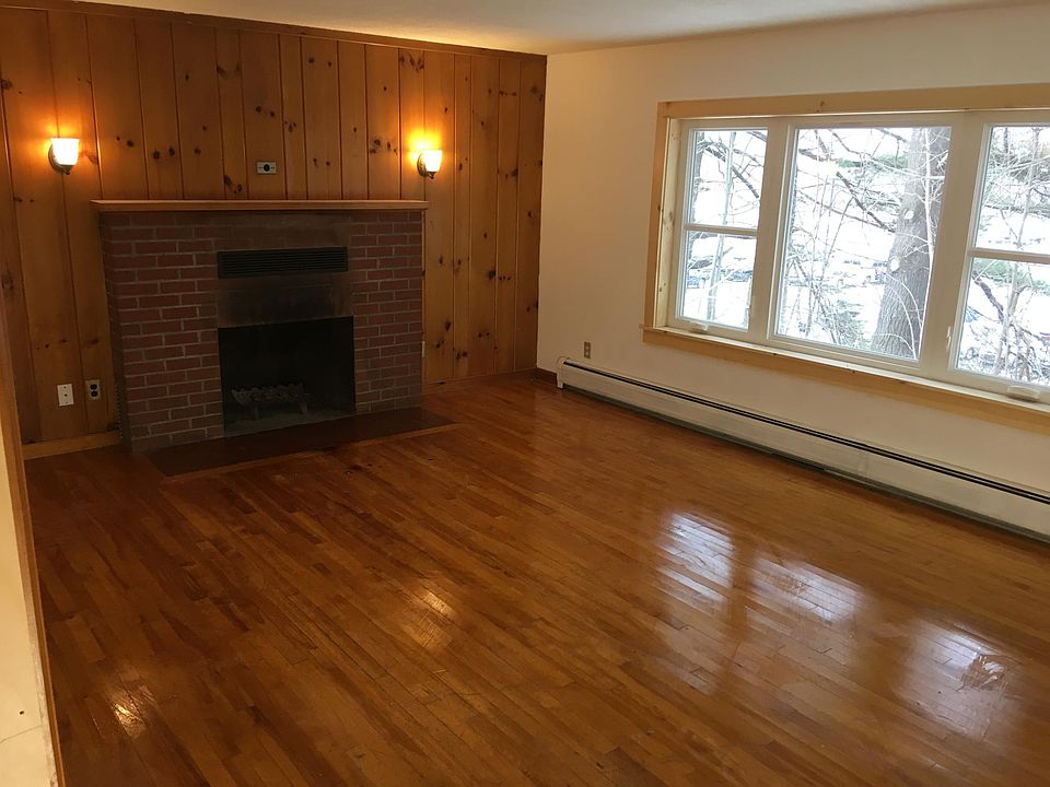 Expansive living room with fireplace and hardwood floor.