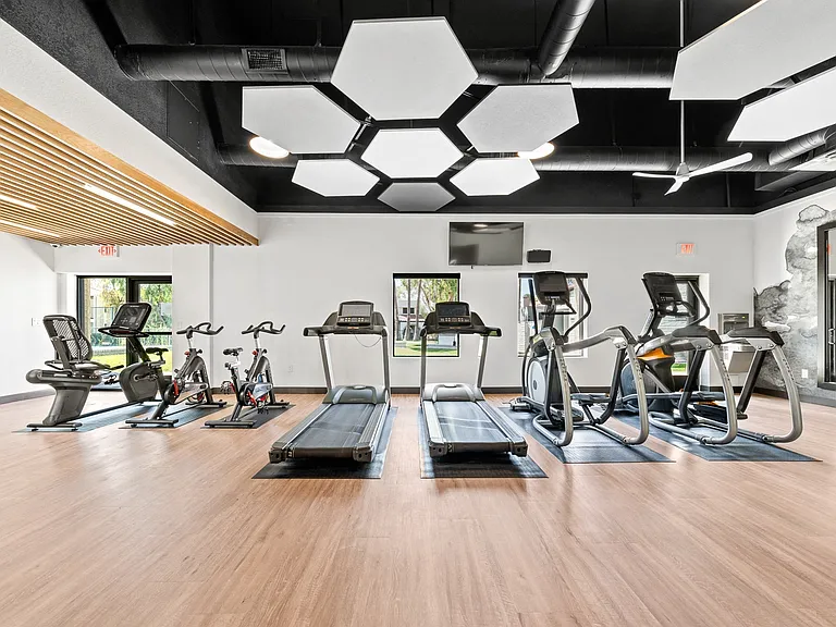 a spacious fitness center with treadmills and ellipticals