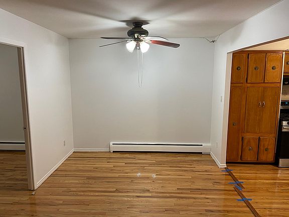 Dining room with ceiling fan off kitchen.