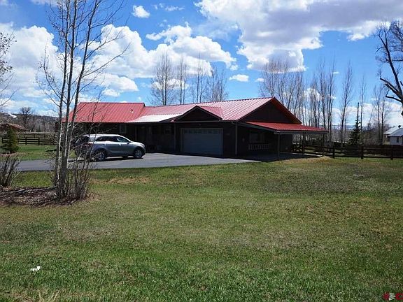 Fronts Meadow Lark Trail.  Paved driveway, landscaped lawns.