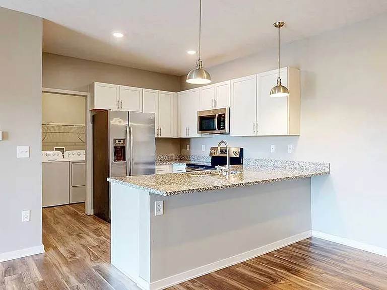 Cook, dine, and gather with ease in this modern kitchen featuring granite countertops, stainless steel appliances, and a spacious breakfast bar.