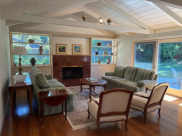 Bright living room with sliding door to back patio and lush back yard