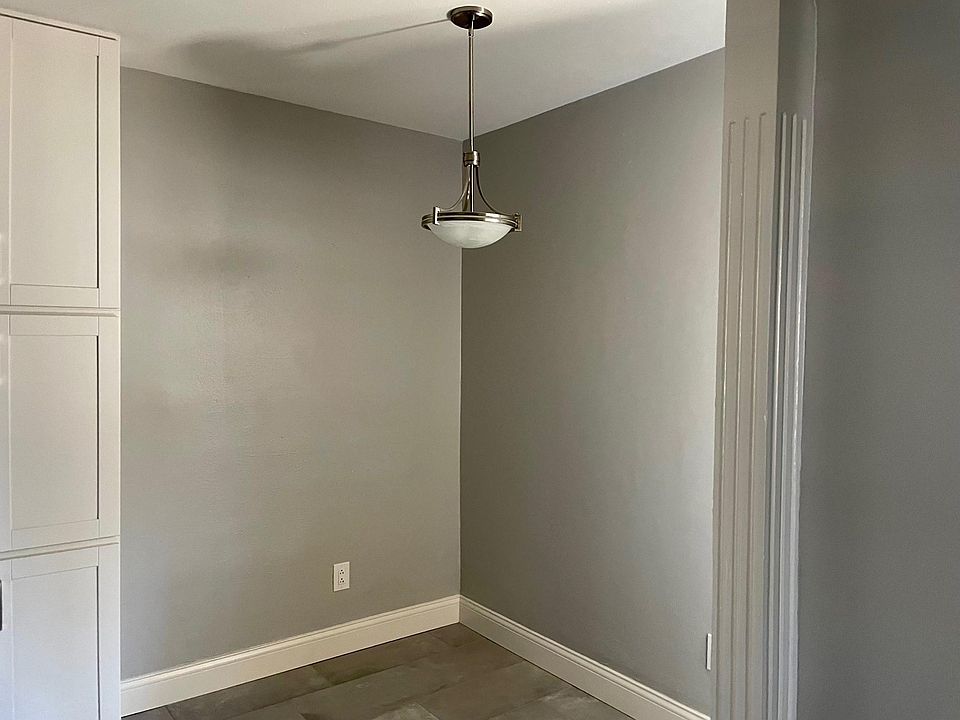 Breakfast nook/dining area off kitchen. Warm, neutral grey color palette and updated lighting fixture.
