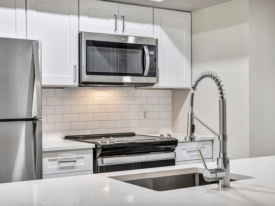 Renovated deluxe home featuring white cabinets and stainless steel appliances