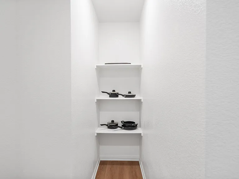 Narrow storage nook with built-in open shelving, ideal for organizing kitchenware, pantry items, or small appliances.
