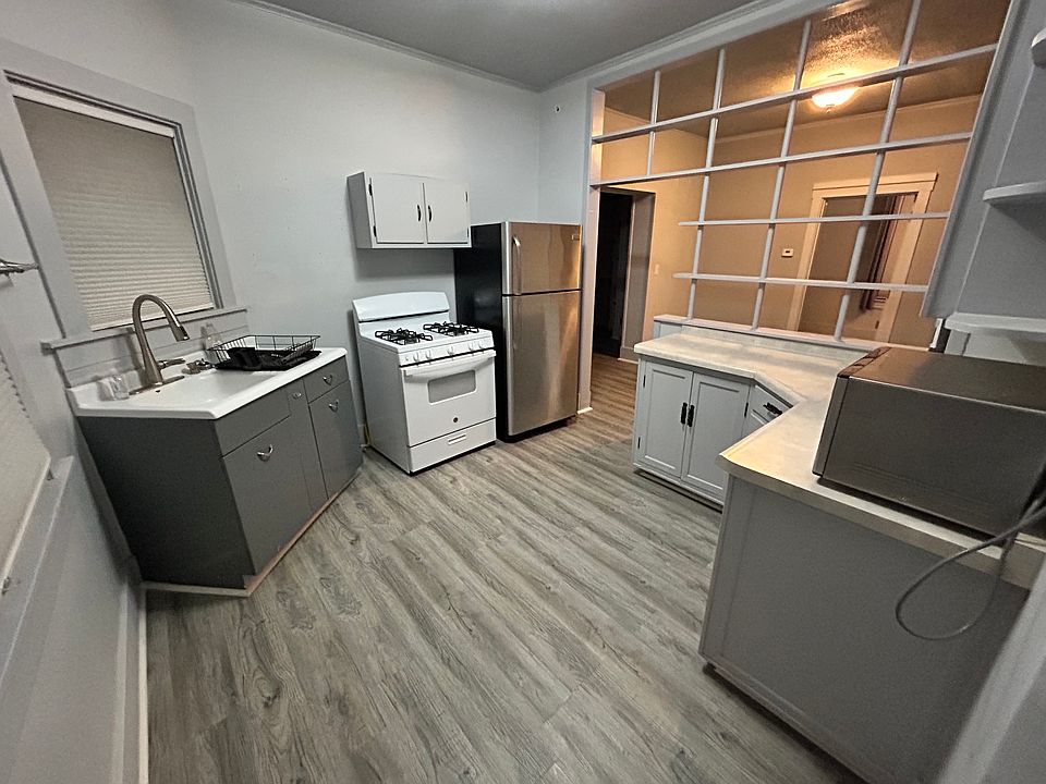 Kitchen with oven, fridge, microwave, sink and counters