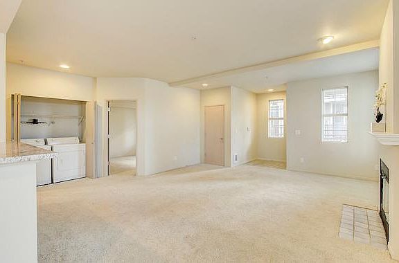 Living room facing the front door, guest bedroom and washer/dryer