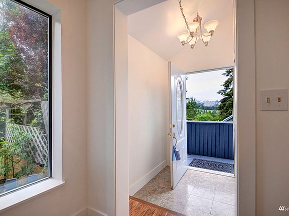 Marble entry segues to distinctive Acacia laminate hardwoods throughout both levels. Note strategic window placements that take advantage of the lush greenery surrounding the home. >