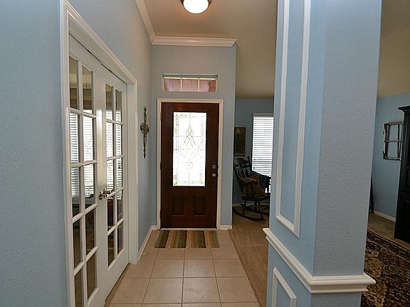 Elegant entry offering a beveled glass front door, tile floors and crown molding.