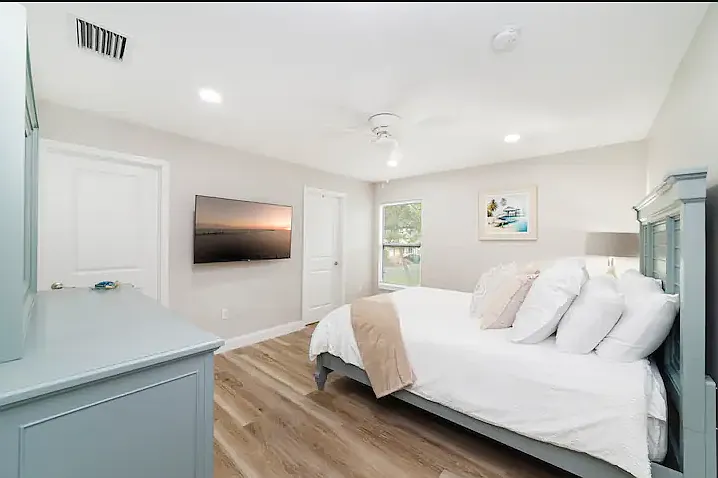 Primary bedroom has a queen bed, dresser, closet, smart TV, and ensuite bath.