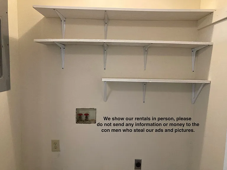 Laundry hookups with shelves above.