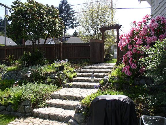 Landscaped yard is full of interesting details such as stone stairs.