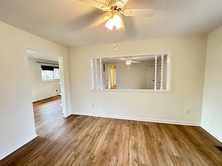 Additional view of the bonus room with views into the living room, dining room and kitchen.