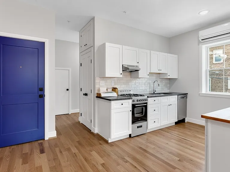 Through the kitchen is a hallway with two storage closets and a half bath. Past the half bath is the stairway to the the upper floor.