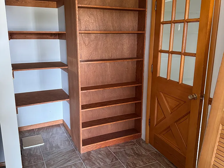 Large kitchen pantry with doors that will be put on after the wall paint dries.