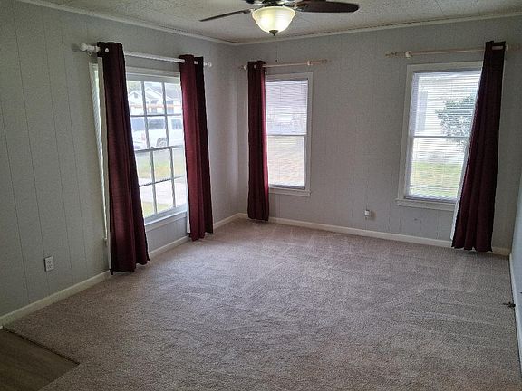 Living area with ceiling fan windows face west and north