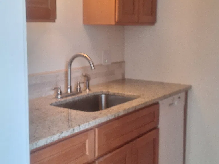 A pantry with a dishwasher and plenty of cabinets on both sides