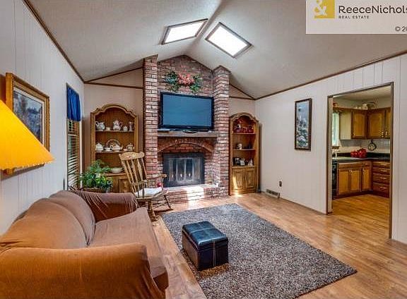 Open Family Room with beautiful, brick fireplace open to kitchen