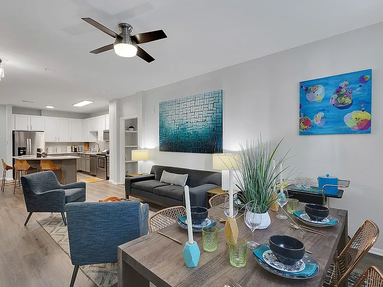 Inviting open-concept living space with modern kitchen, cozy lounge area, and stylish dining setup, perfect for social gatherings.