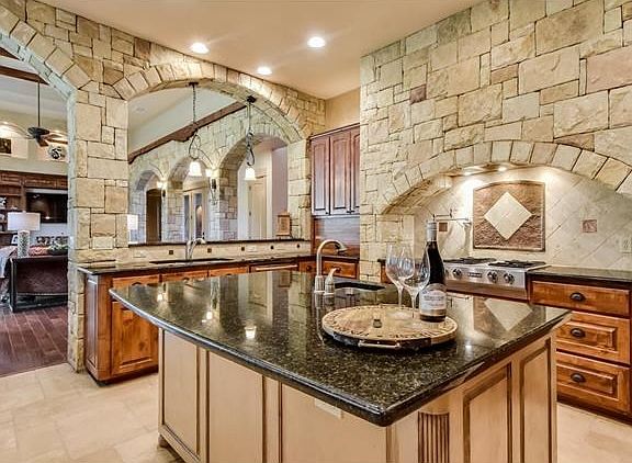 You can never have too many cooks in this custom kitchen.  Black granite counters, alder cabinets, travertine tile, gas range and built in fridge.