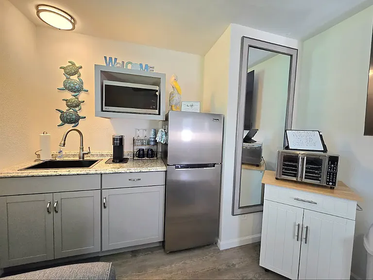 The kitchenette has dishes, utensils for cooking & eating, a double electric burner, pans, an airfry oven on the cart, full fridge, & crockpot.