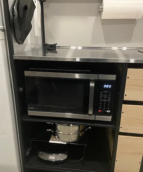 New microwave conveniently located under the stainless steel counter.