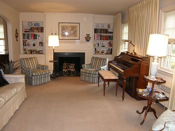 Inviting living room with wood burning fireplace framed by built-in shelves