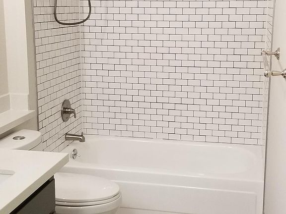 Tile floor and tub surround, quartz countertops and washer dryer