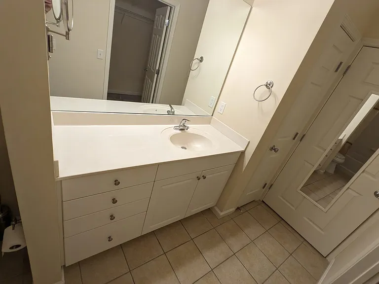 Master bedroom furnished with a king-size bed and a dresser with a mirror