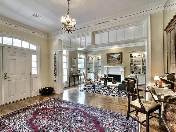 The entry hall is elegant, airy & bright. Note the custom dentil moldings & graceful transoms. All l