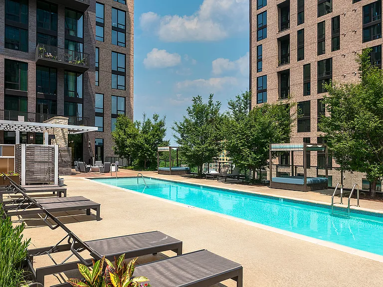 Resort-style saltwater pool with cabanas and sundeck seating