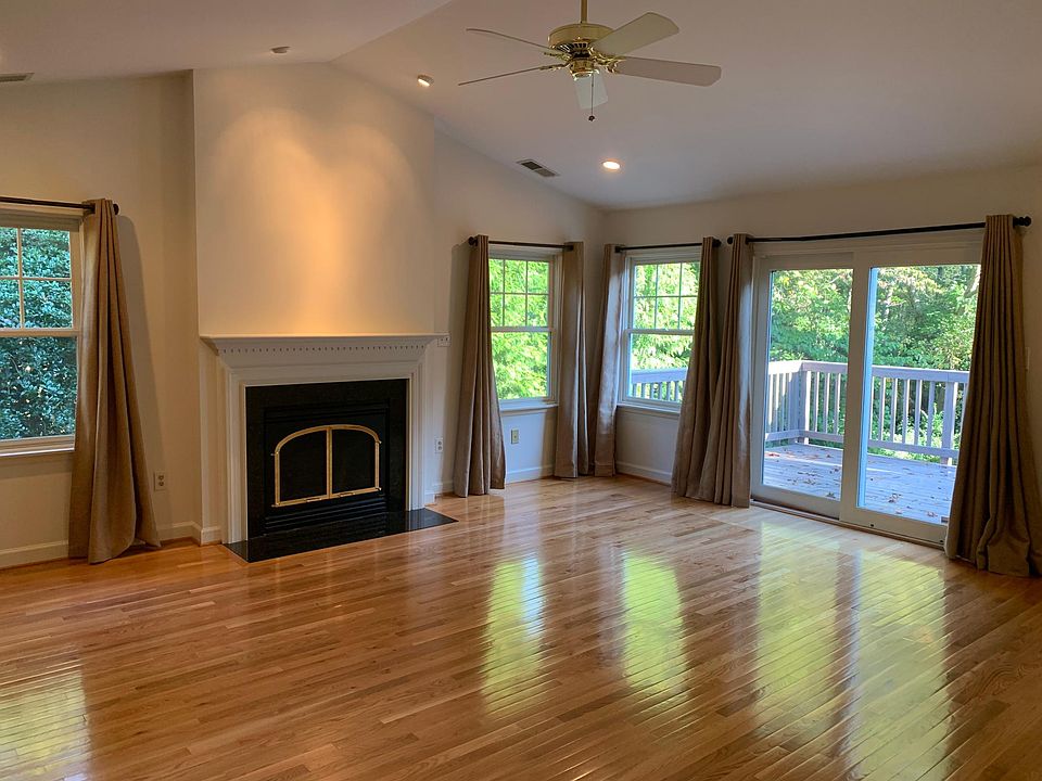 Living room with vaulted ceilings, ceiling fan, gas fireplace and access to private deck