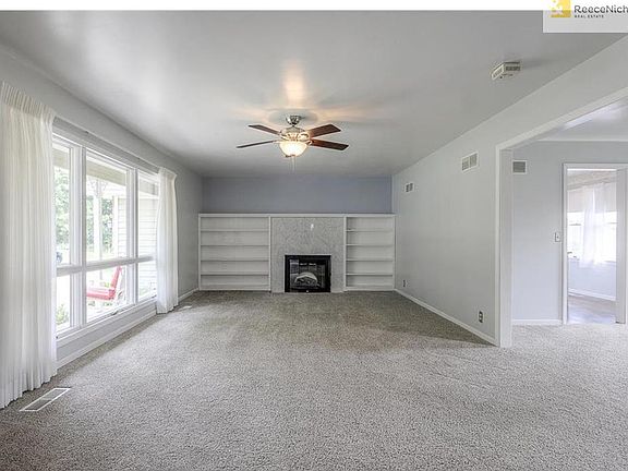 Great room, fireplace with marble tile surround and built in book cases.