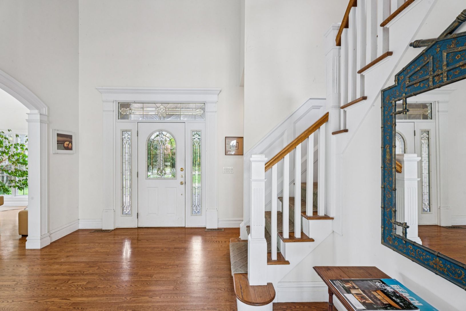 Elegant foyer featuring oak floors, soaring cathedral ceilings, and timeless arched walkways.