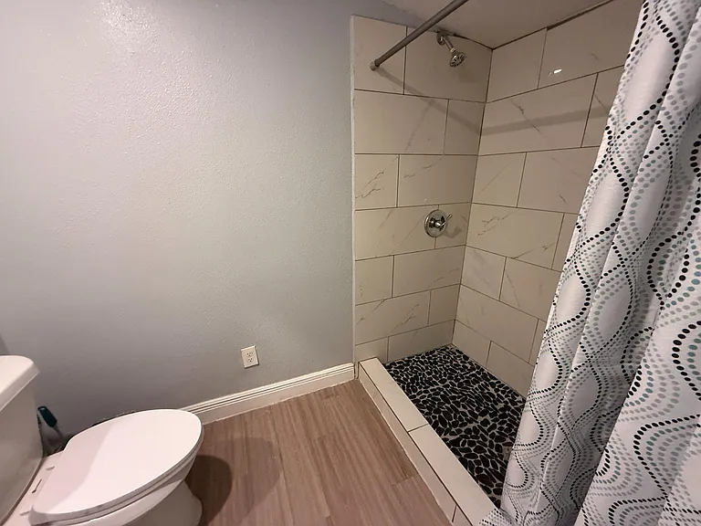 Updated bathroom features a tiled walk-in shower with pebble-style floor and easy-clean finishes for everyday use.