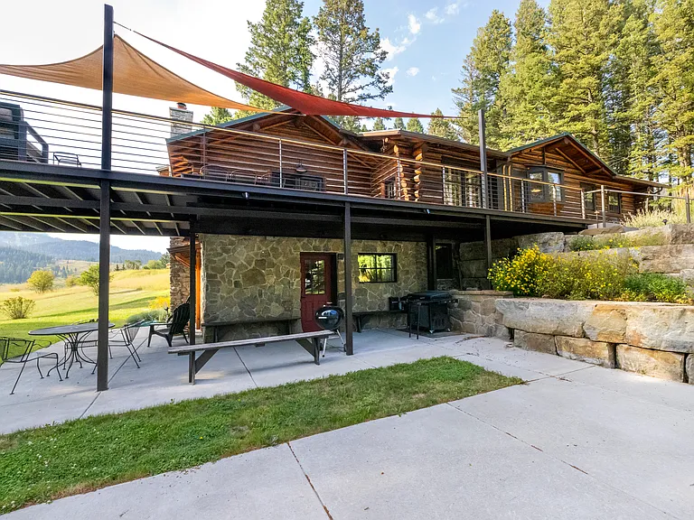 lower parking area and entrance to lower family room and mud room. Blackstone BBQ and Weber grill under deck