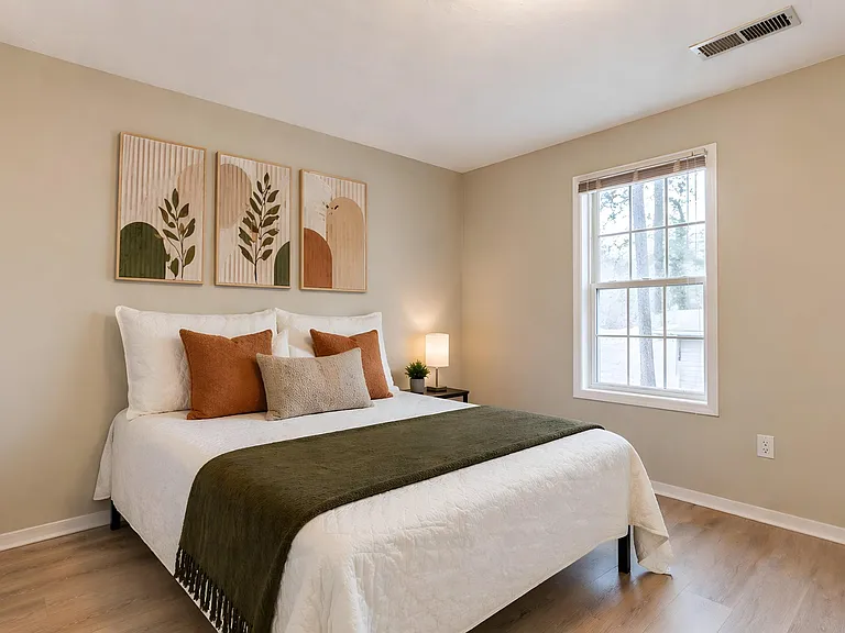 Well-appointed bedroom with a comfortable bed, nightstand, and large window for natural light and outdoor views.