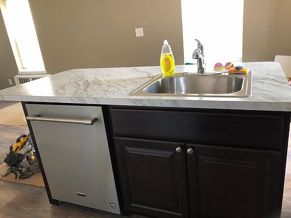 Center island view towards light filled window and rear entrance of unit