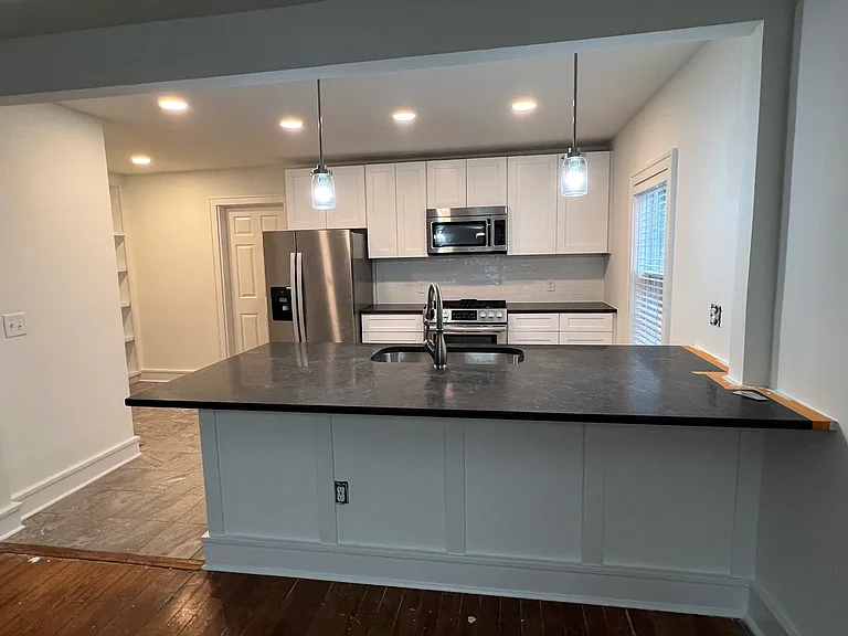 Renovated kitchen with wood cabinets and honed black pearl granite countertops. Stainless steel appliances with a gas range. Nice space for bar chairs under countertop.