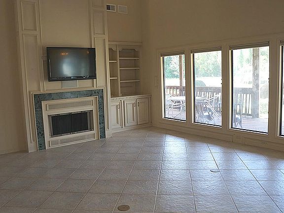 Open family room with a beautiful view of the lake.  Recent custom blinds