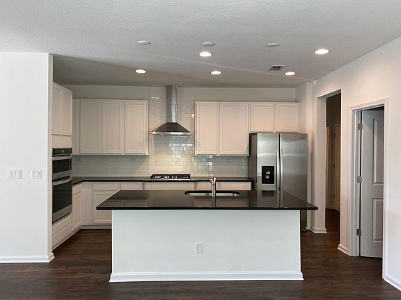 Kitchen with quartz countertops, subway tile backsplash and gas range. All appliances shown are included!