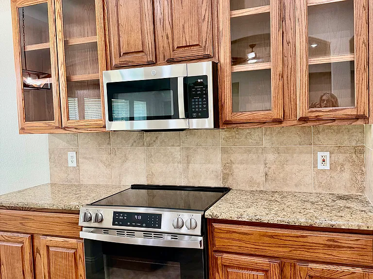 Stainless Steel appliances and glass front cabinets