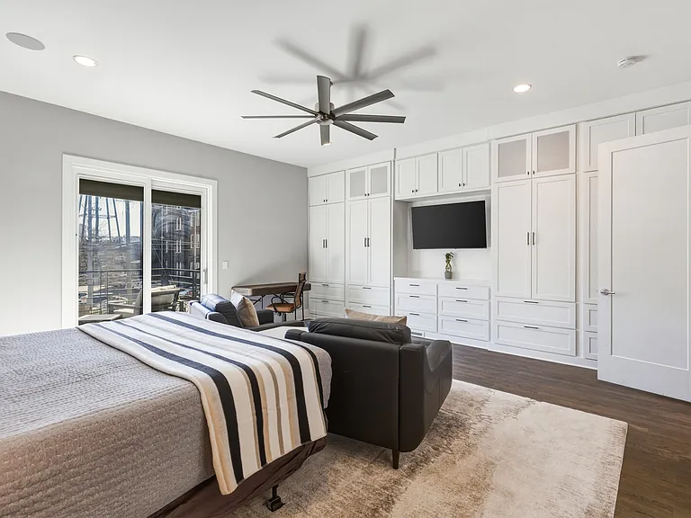 Spacious primary suite featuring a plush king bed, cozy seating area, walk-in closet with custom built-ins, spa-like bath, smart TV and private access to an 11x9 deck. Your private retreat to unwind in comfort.