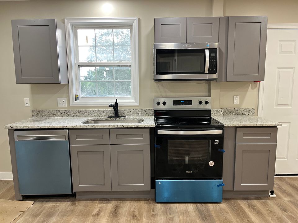 All new! Soft close cabinets, Quiet decibel dishwasher, new stove/oven, and microwave with vent. Four windows bring in great lighting in this open floor plan kitchen living area.