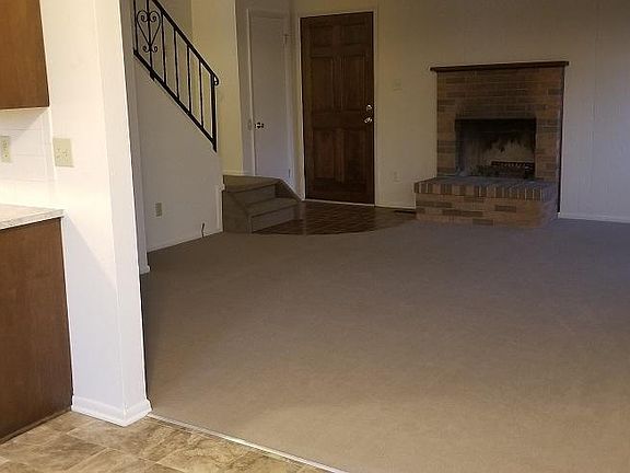 Towards front door, from dining area with kitchen on left.