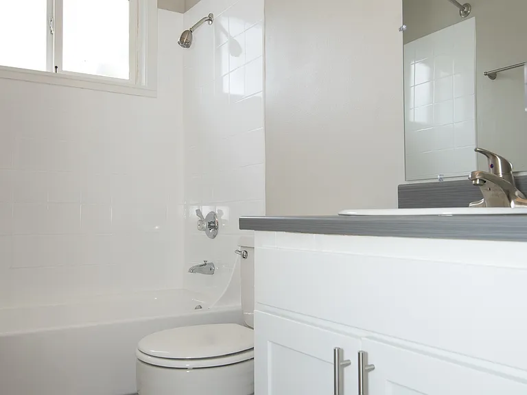 Bathroom with Grey Counters and Bathtub