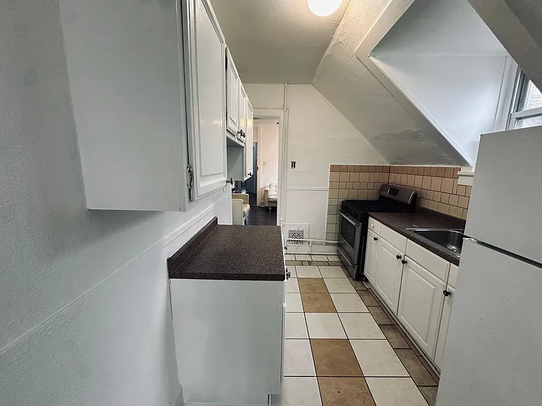 Kitchen, in the back living room door. Tile floors and backsplash.
Fridge, gas stove, sink. North facing window.
